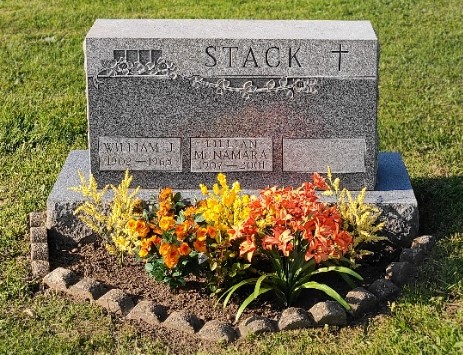 Clean headstone with repaired border and permanent flowers